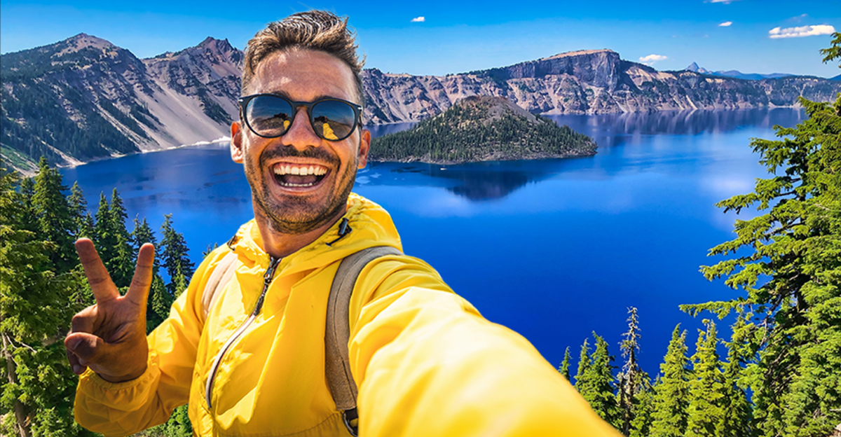 Man in yellow jacket taking a selfie, Crater Lake National Park