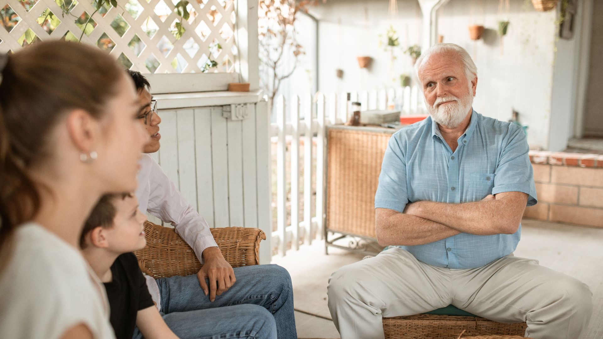 Family gathered indoors, engaged in conversation with a focus on bonds and togetherness.