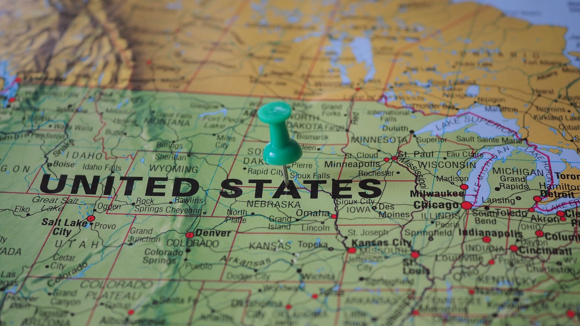 High-angle view of a map featuring the United States with a green pin indicating a specific location.