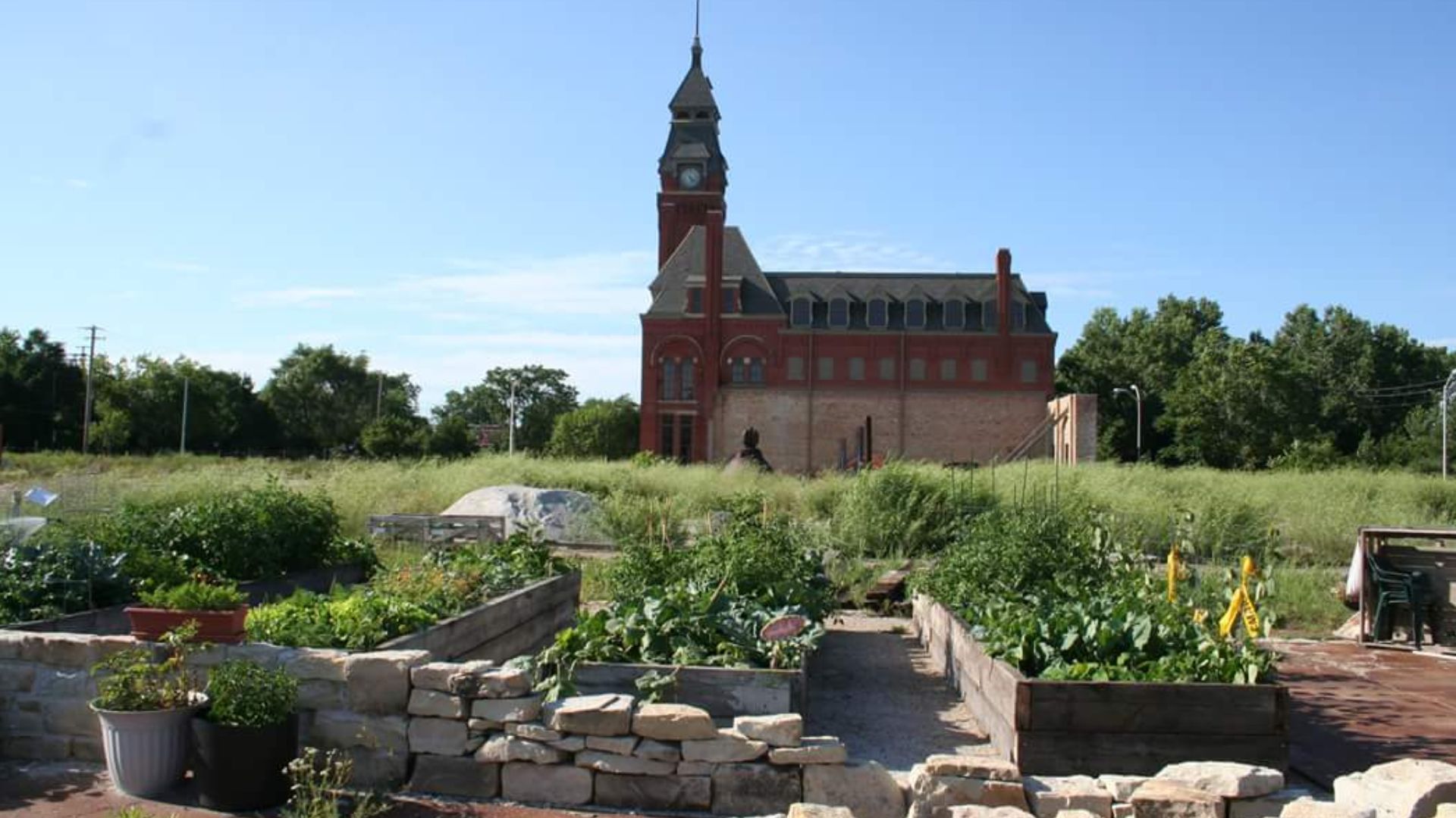 The Administration Building (Clock Tower) of the Pullman Palace Car Factory, as seen from the south. Also shown is the Pullman Urban Gardens project (foreground).