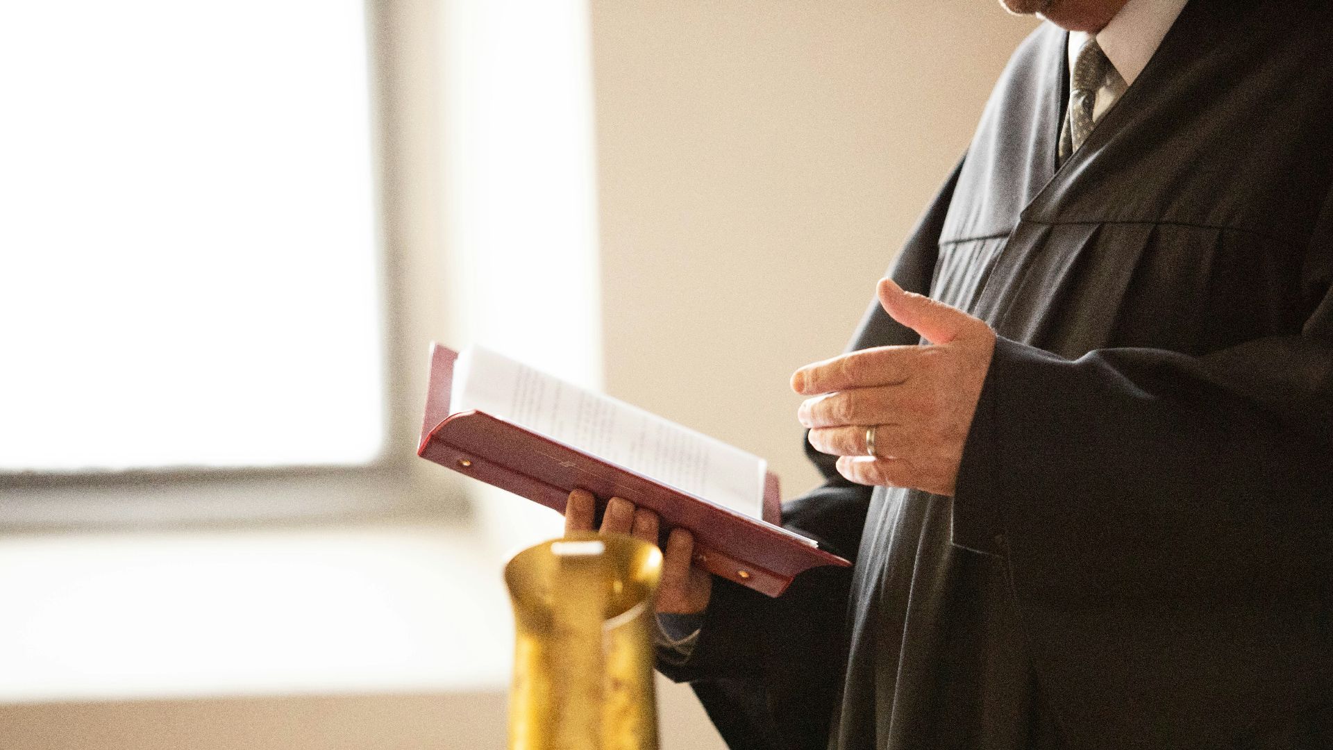 a man in a black robe holding a book
