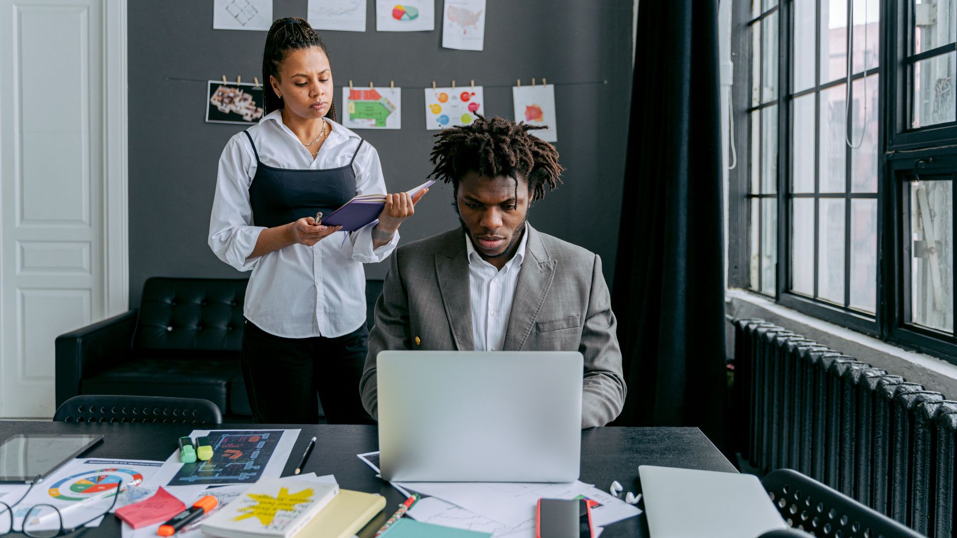 Two colleagues working together on a project in a stylish, modern office environment.