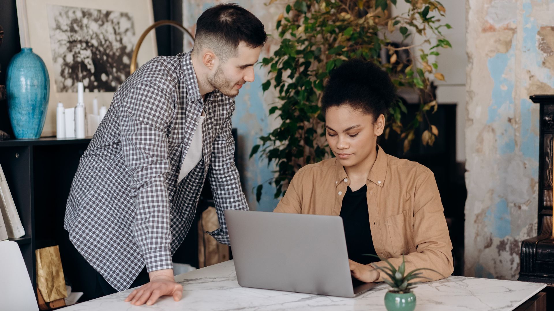 A focused team working together in a stylish office setting with laptops and decor.