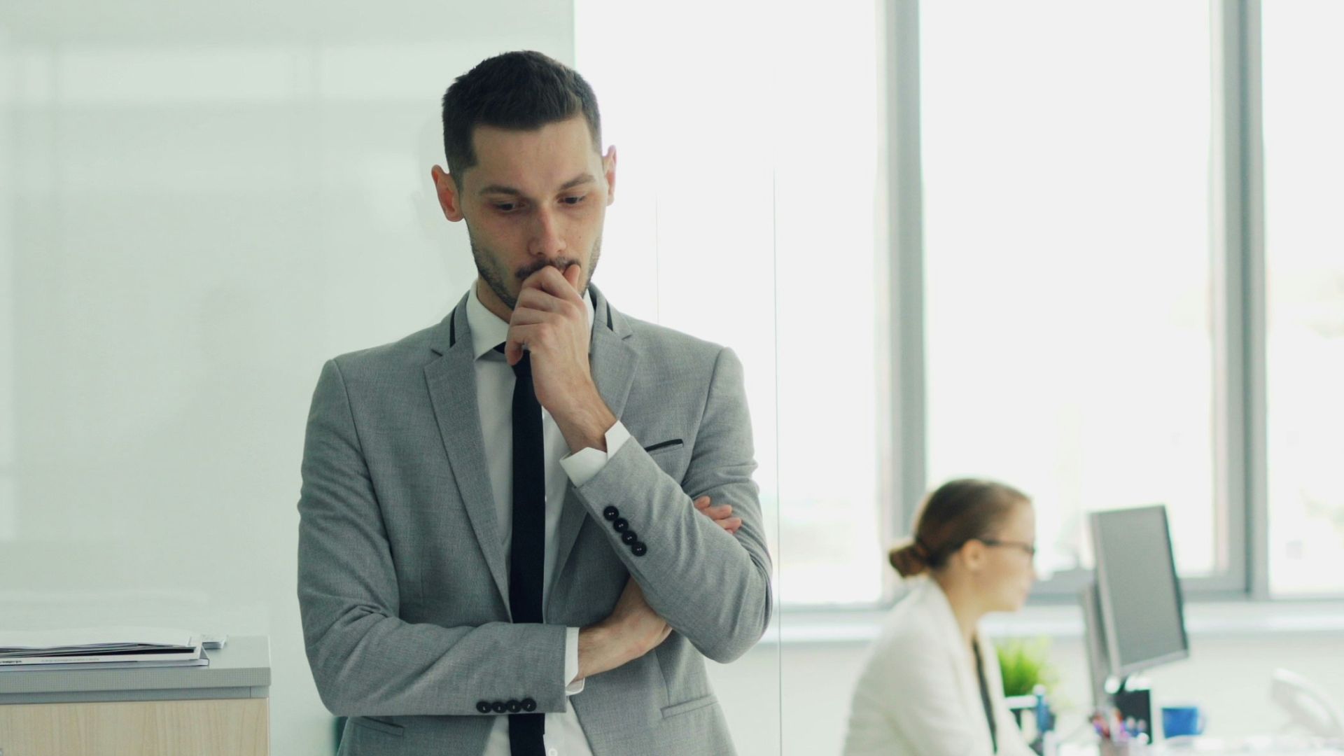 Man in suit thinking in modern office environment