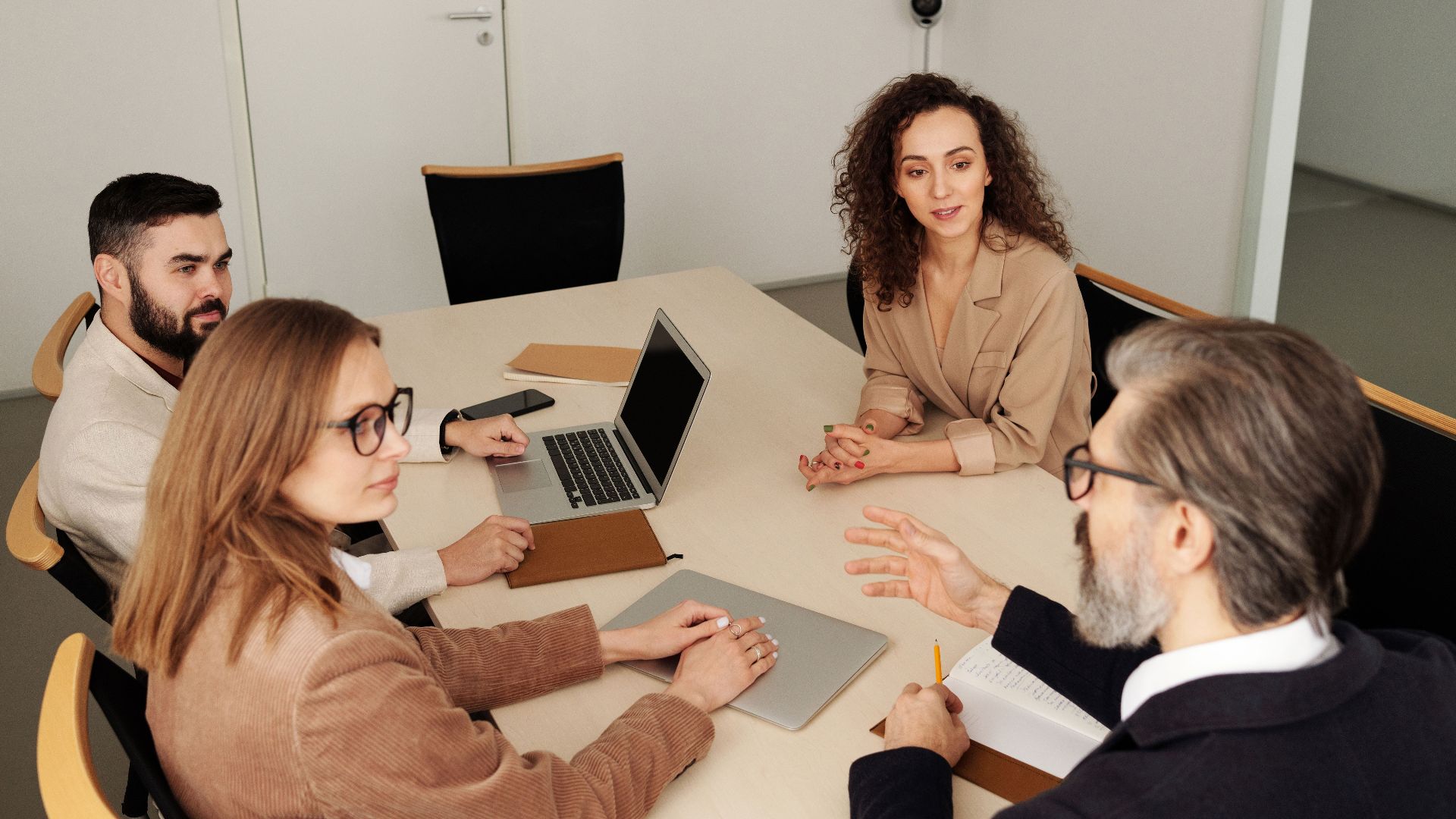 Professional team engaged in a meeting at a modern office table, discussing business strategies.