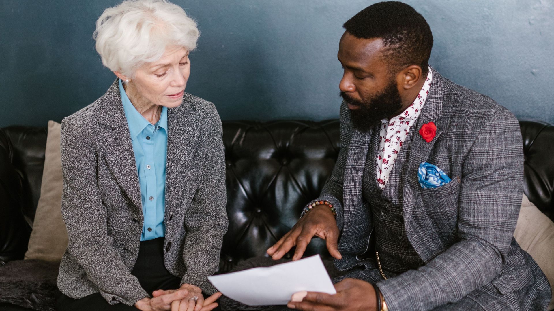 Elderly woman and man discussing documents in a professional setting.