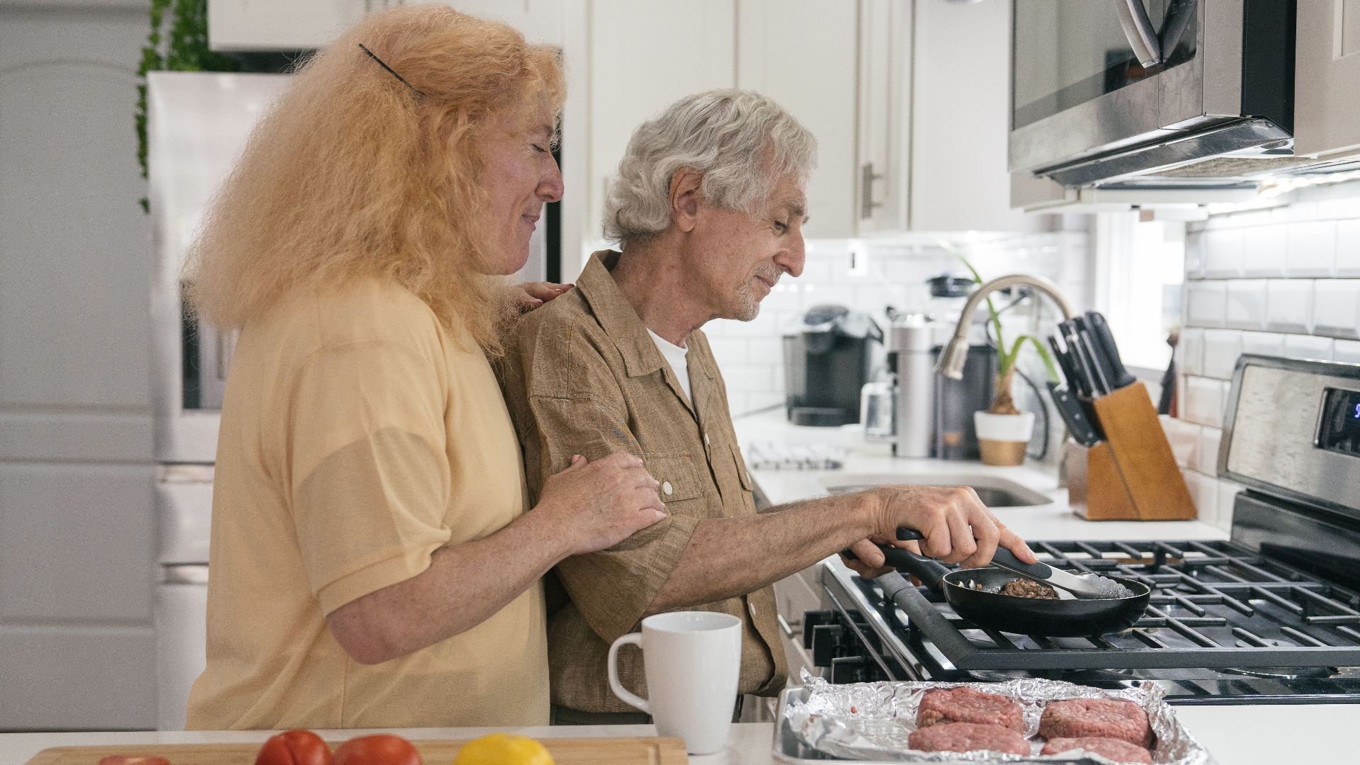 Senior couple enjoying quality time cooking together in a modern kitchen setting.
