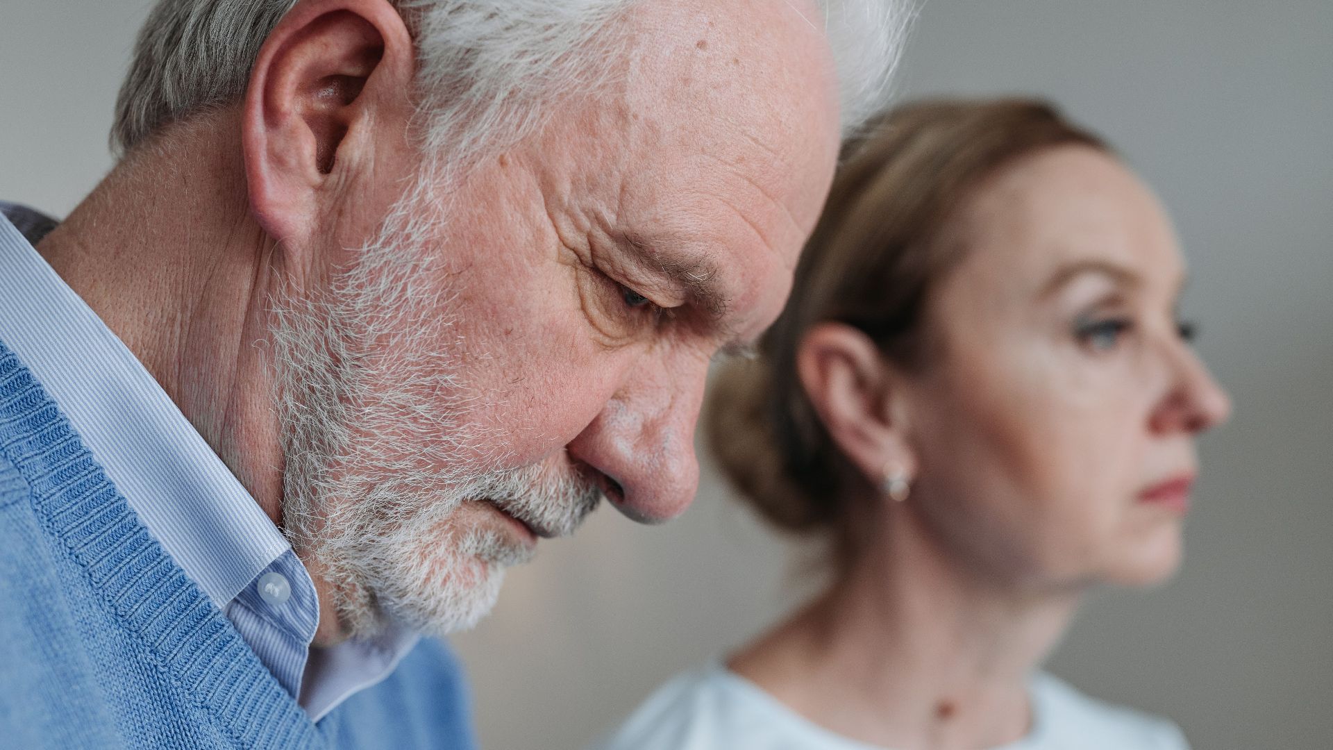 Close-up portrait of an elderly couple experiencing deep emotions and reflection.