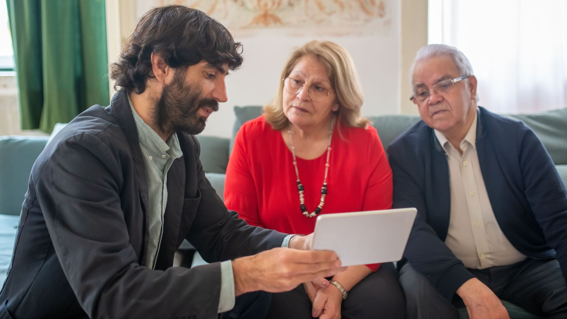 A financial advisor discussing investment options with an elderly couple in a cozy living room.