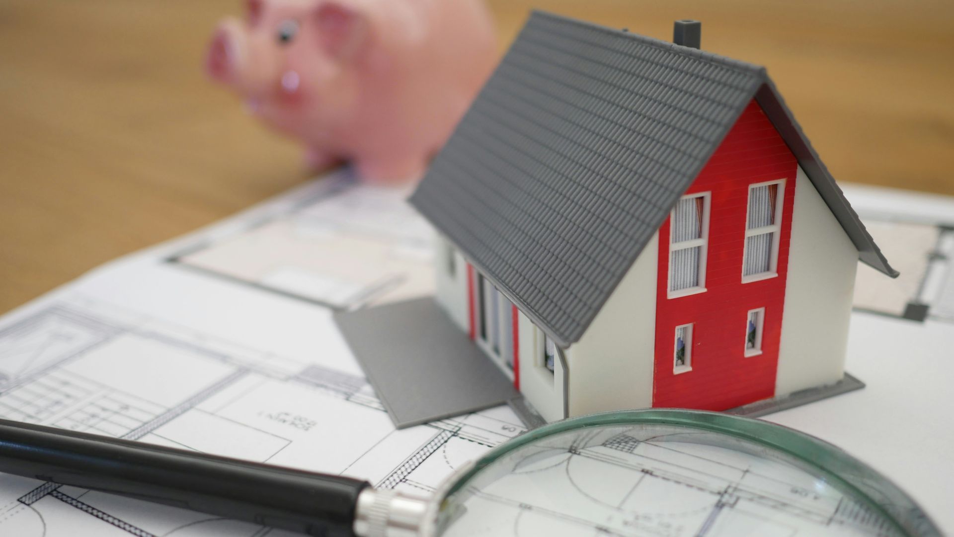 white and red wooden house beside grey framed magnifying glass