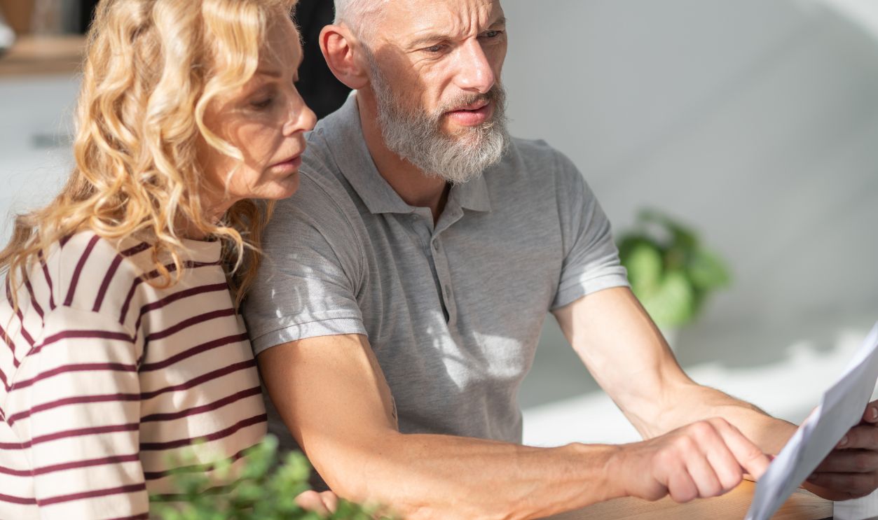 A mature couple scrutinizing the papres and searching internet