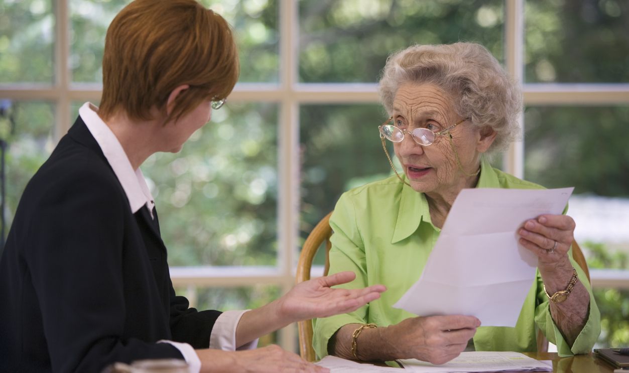 Mature woman talking to financial planner at home
