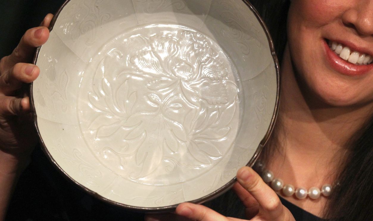 Edie Hu, Senior Specialist, Chinese Ceramics and Works of Art Departments shows a large flower-shaped bowl is " The Clark Ding Basin ", A Magnificently Carved Dingyao Basin, Northern Song Dynasty, expected to fetch in excess of HK$60 million, at Sotheby's media preview in Admiralty. 28FEB14