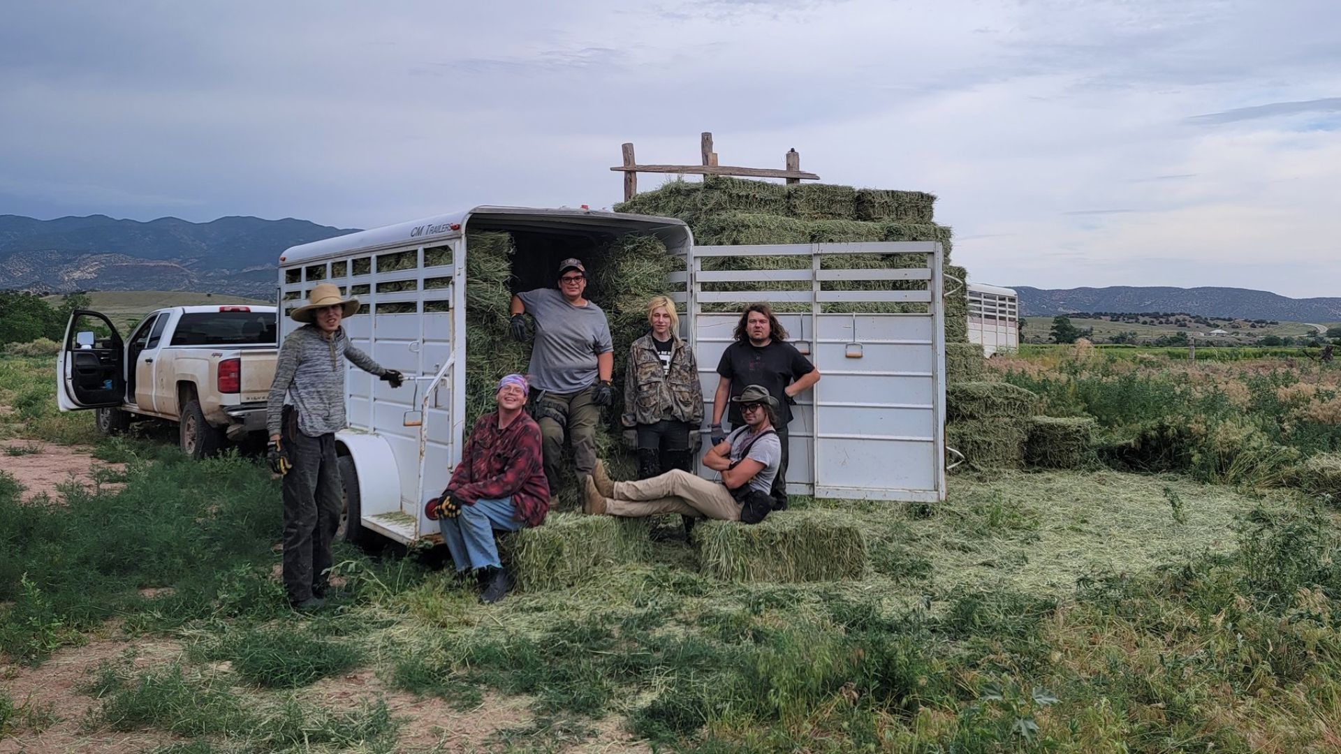 Ranchers at the Tenacious Unicorn Ranch loading hay