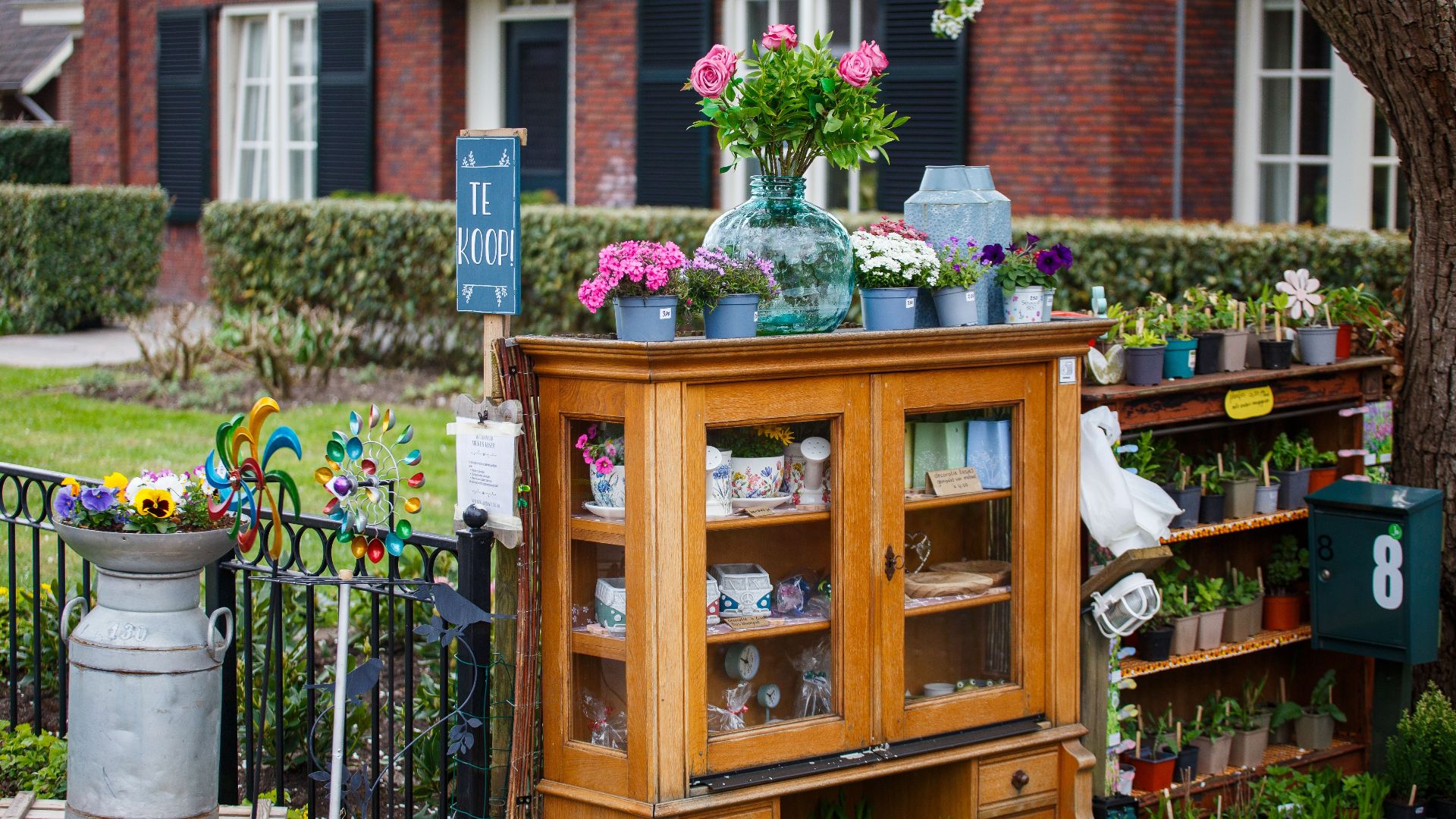 Vintage outdoor cabinet with plants and decor for sale in a garden setting.