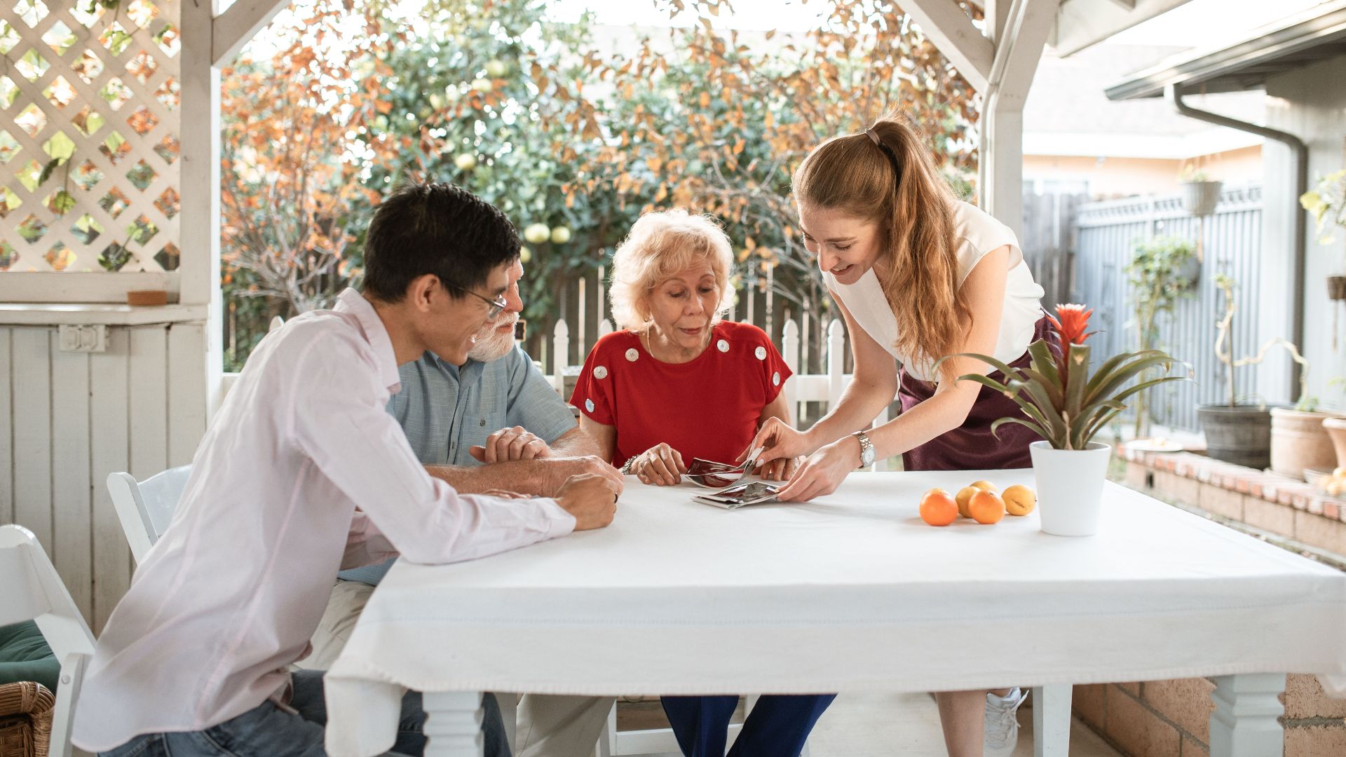 Family sharing photos while seated outdoors, surrounded by nature and smiles.