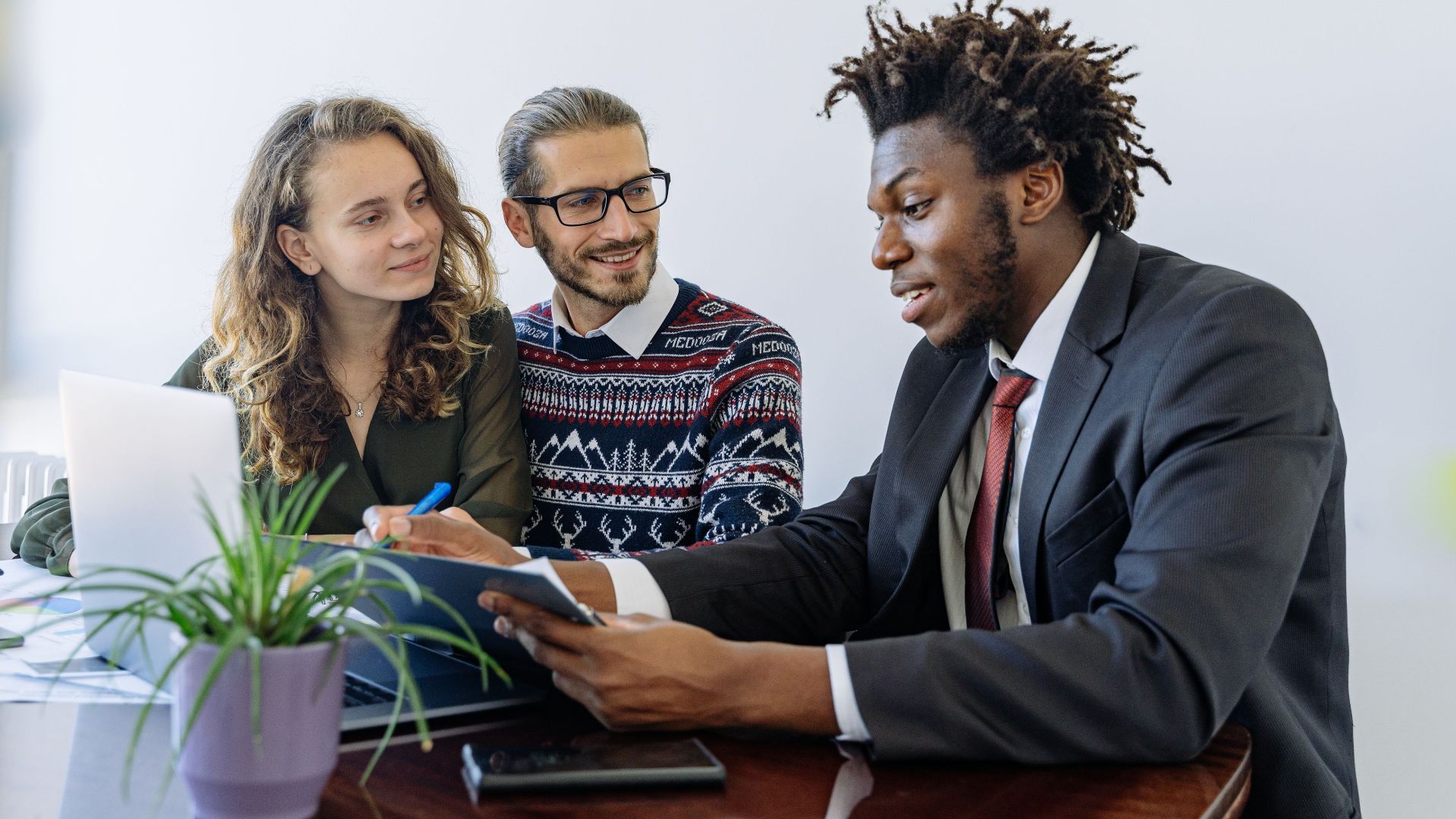 A diverse group of professionals collaborating in an office meeting, showcasing teamwork and partnership.