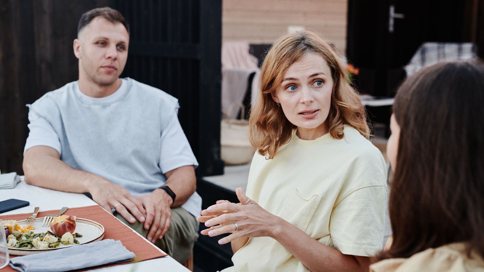 A group of adults enjoying a relaxed outdoor meal together.