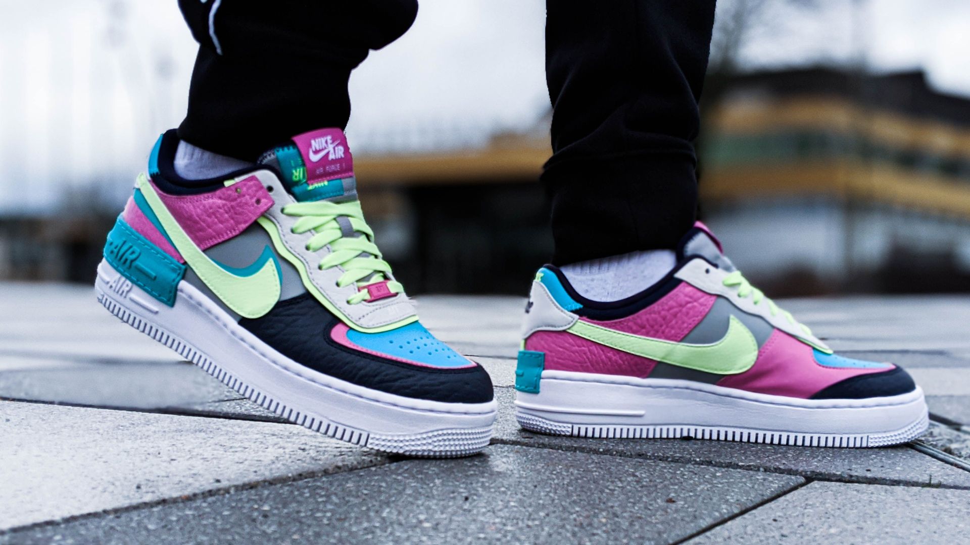 Vibrant sneakers showcased in low-angle shot on urban pavement. Trendy and stylish footwear display.