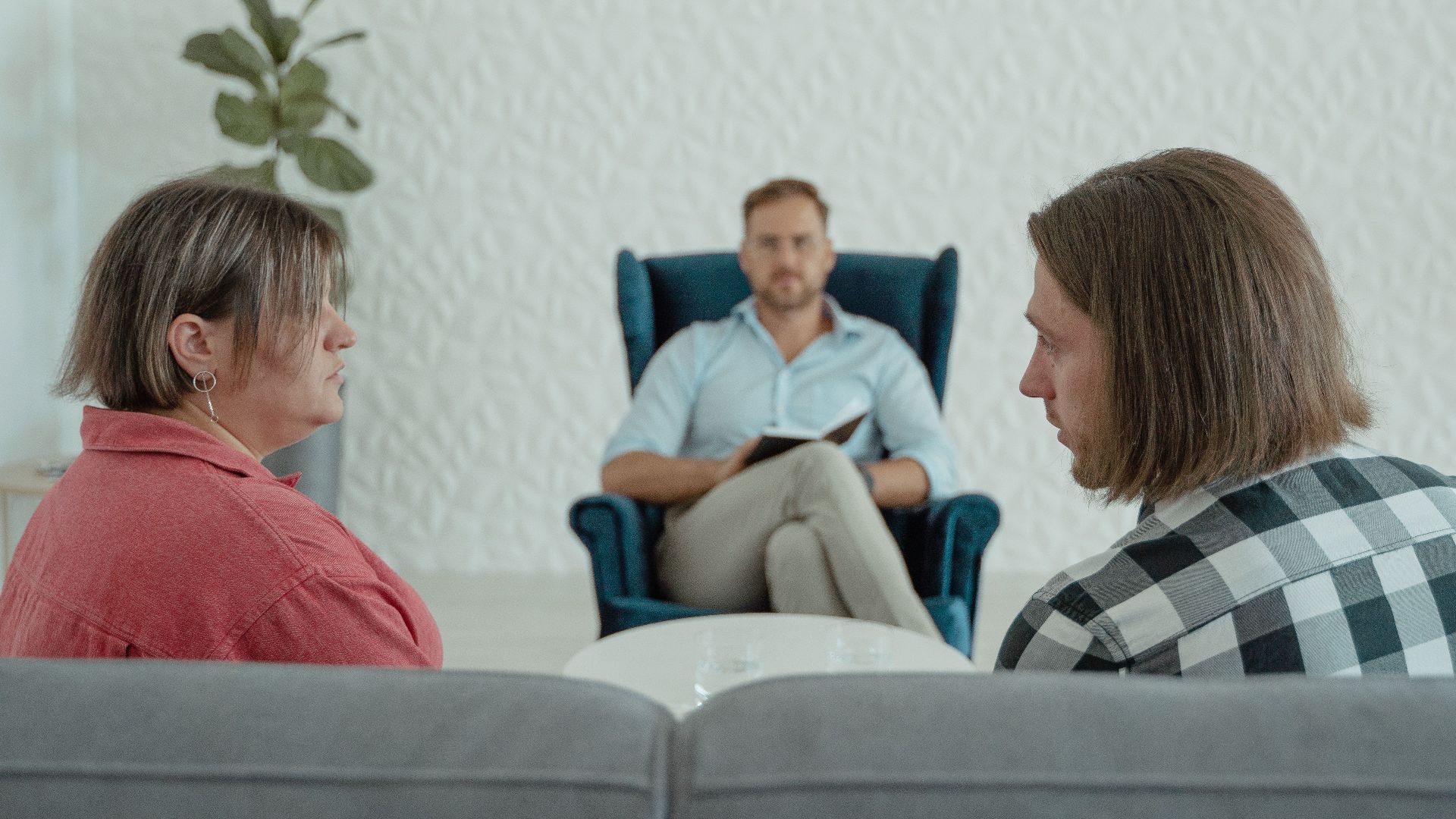 Image of a counseling session with a professional advisor, focusing on a couple's discussion.