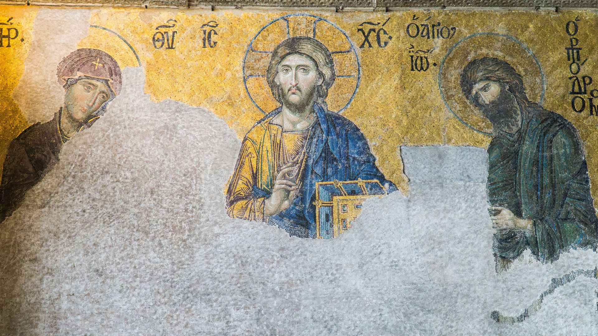 A close-up of a historic religious mosaic in the Hagia Sophia, Istanbul, depicting Jesus, Mary, and John the Baptist.