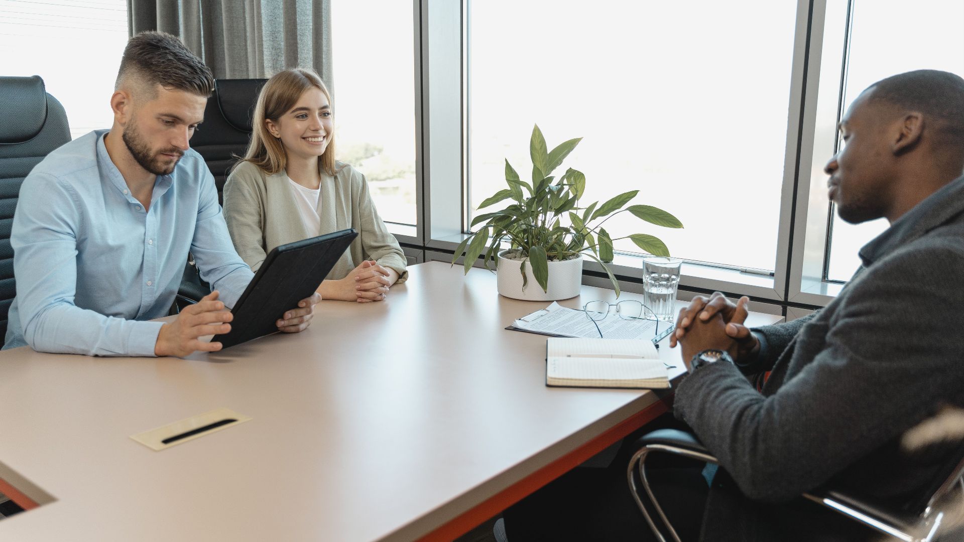 A business interview with three people in a modern office room, highlighting collaboration.