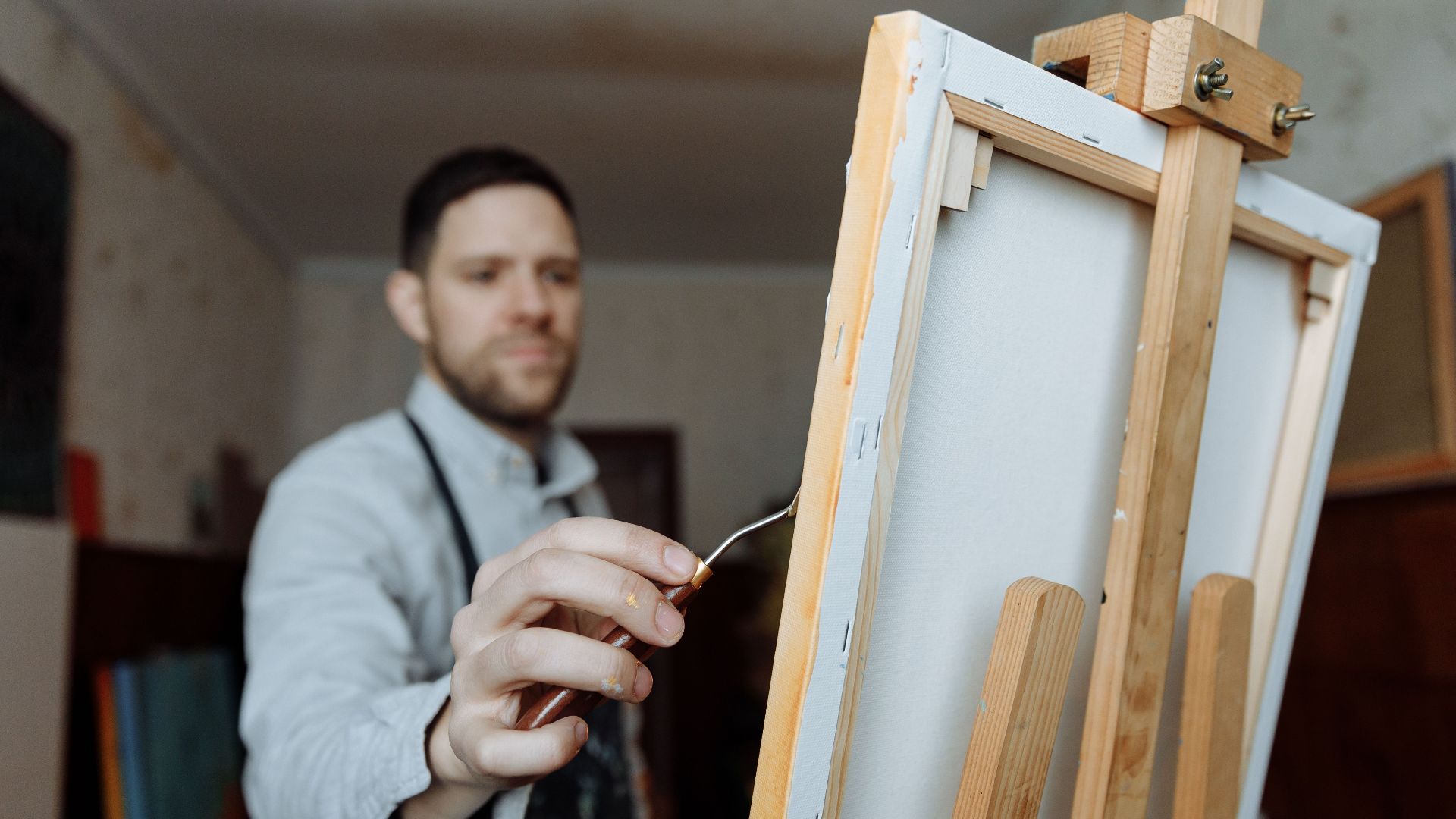 Artist in studio painting on canvas, showcasing creativity and passion.