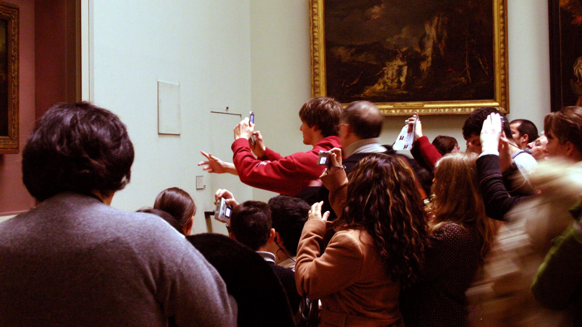Visitors take photos of the Mona Lisa at the crowded Louvre Museum in Paris.