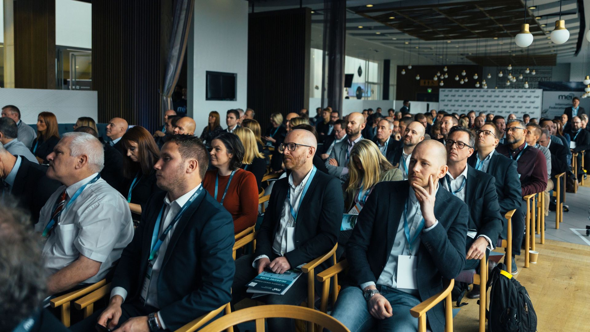 Business professionals attentively listening at an indoor conference meeting.