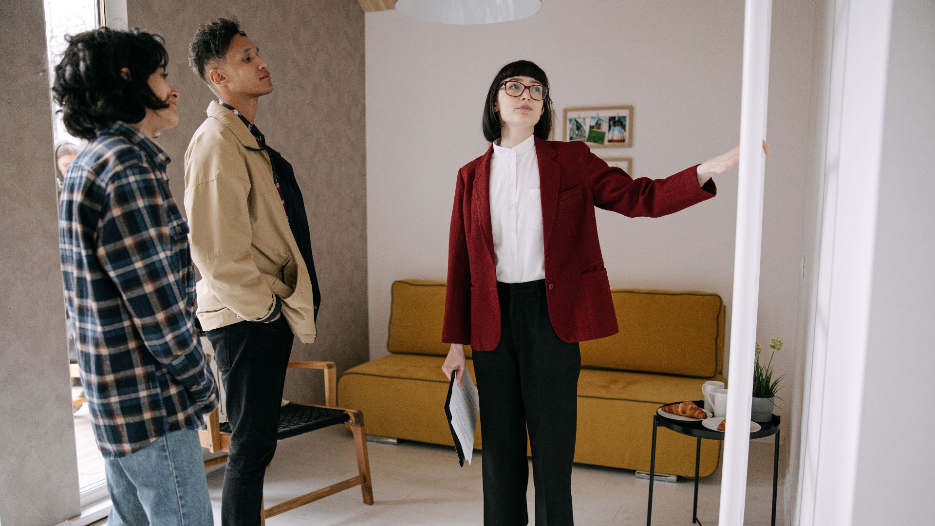 Realtor guiding potential buyers through a stylish apartment viewing.