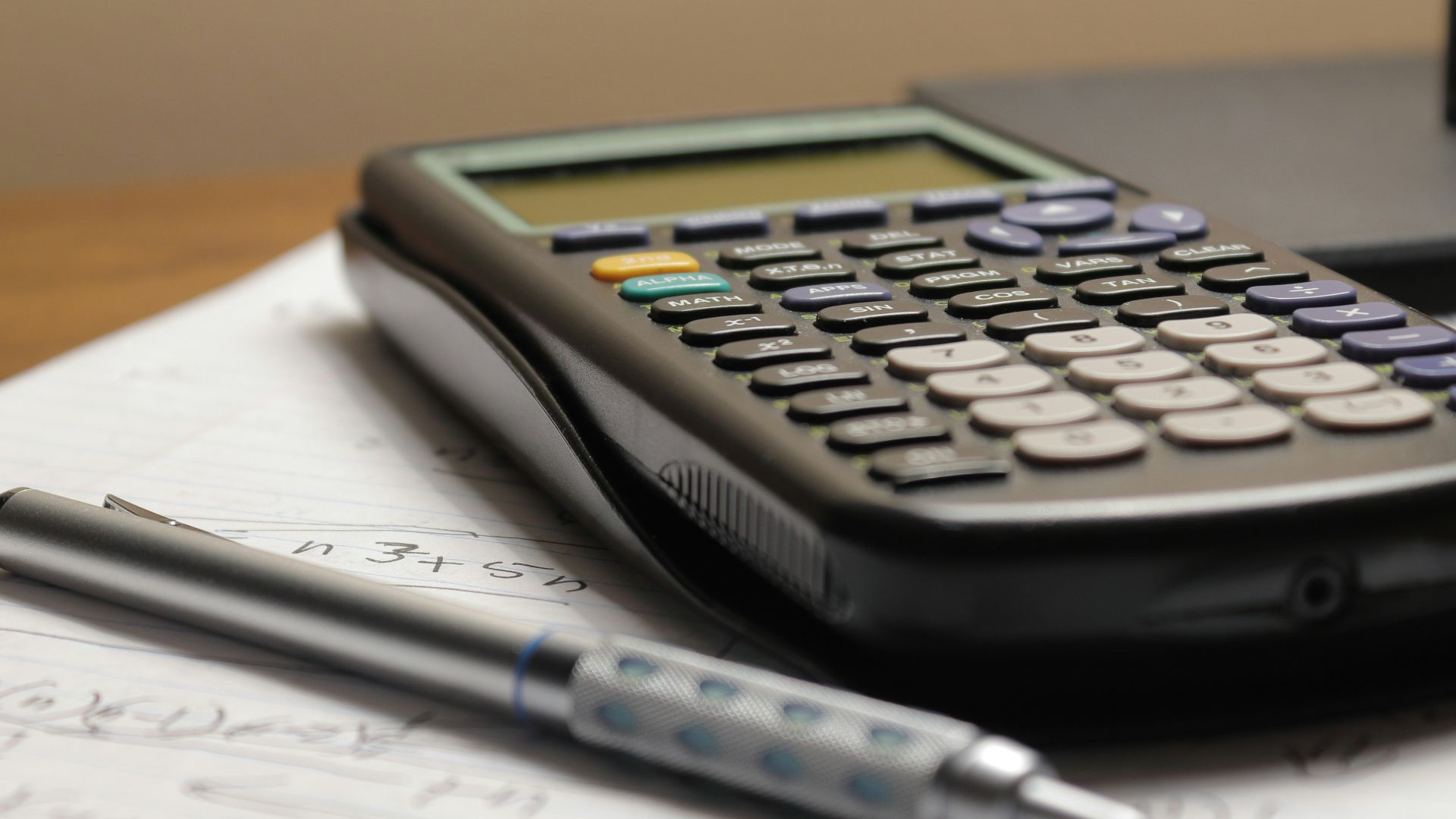 a calculator and a pen sitting on top of a piece of paper