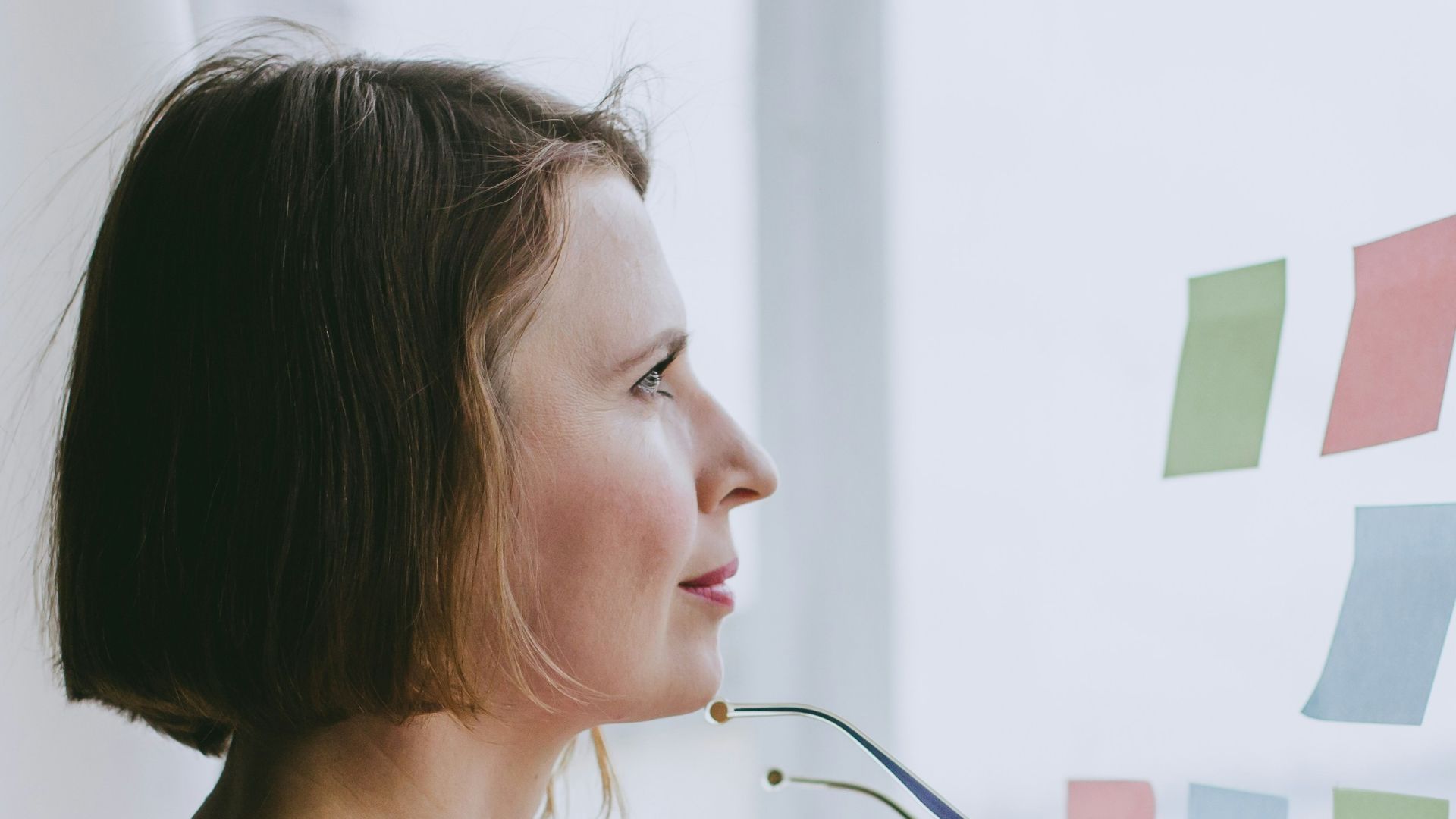 a woman looking out a window with sticky notes on it