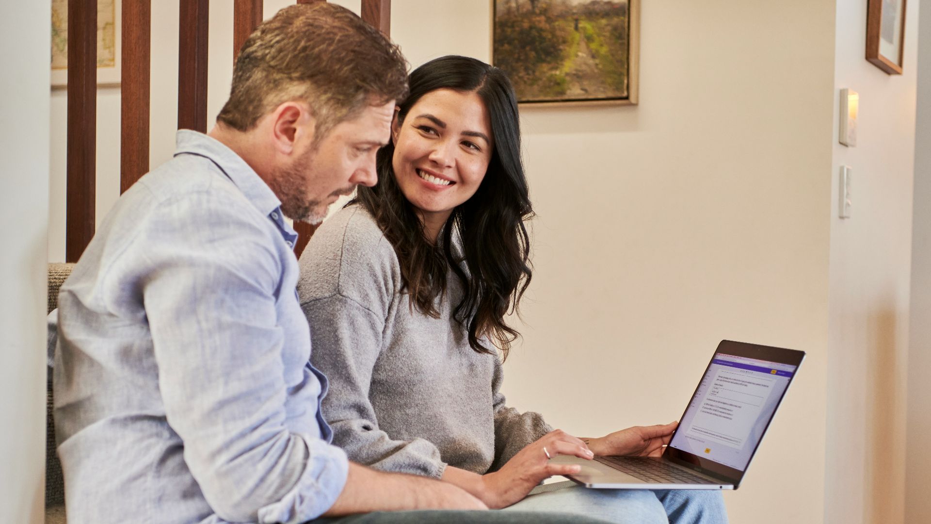 man sitting beside woman looking at a contract on DocuSign