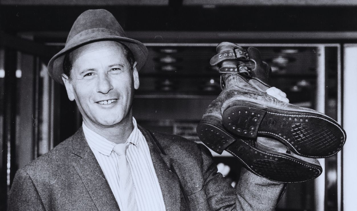 Gettyimages - 530232163, Eli Wallach Actor Eli Wallach smiling as he holds a pair of army boots, as he arrives at London Airport ready to begin filming 'The Victors', England, August 2nd 1962.