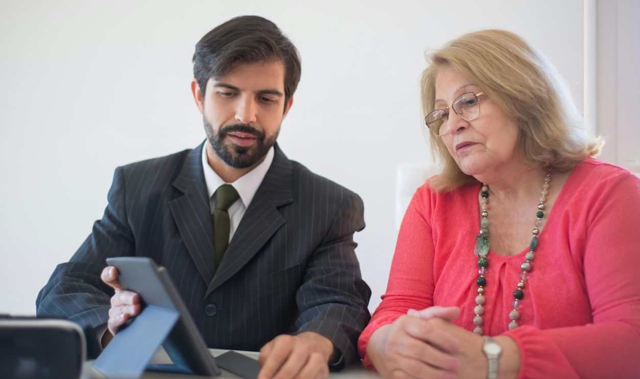 Business meeting in Portugal between a man and senior woman discussing