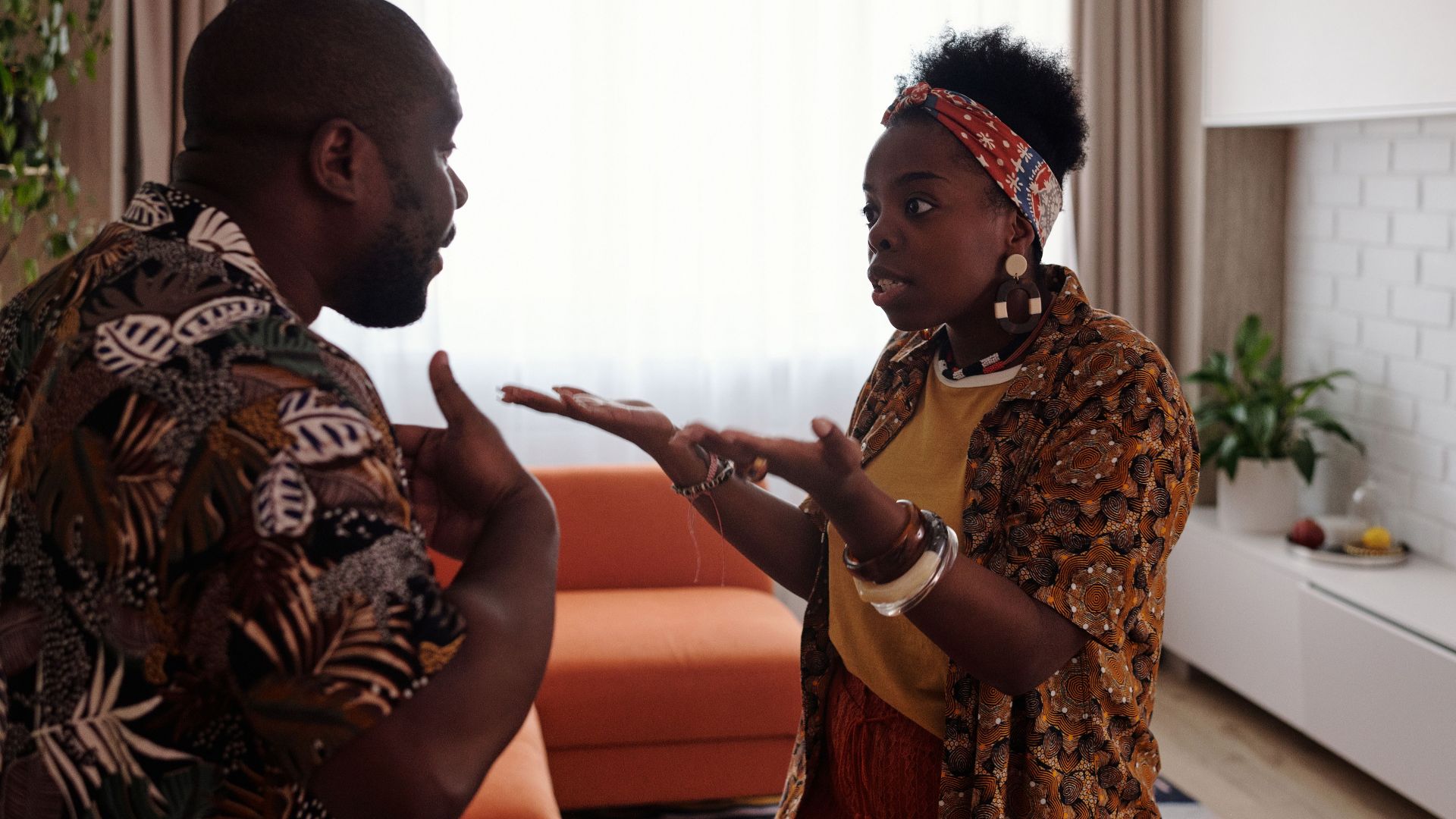 A couple arguing passionately in their living room, expressing emotions and gestures.