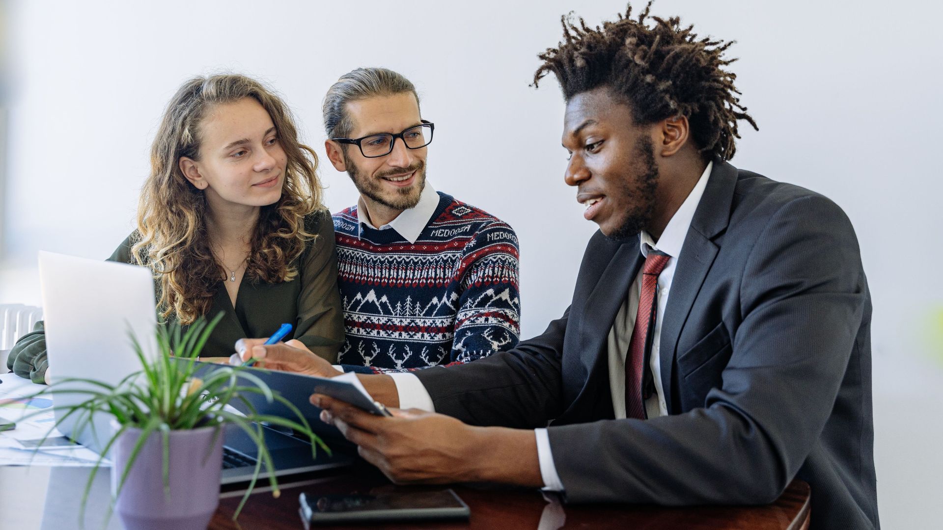 A diverse group of professionals collaborating in an office meeting, showcasing teamwork and partnership.