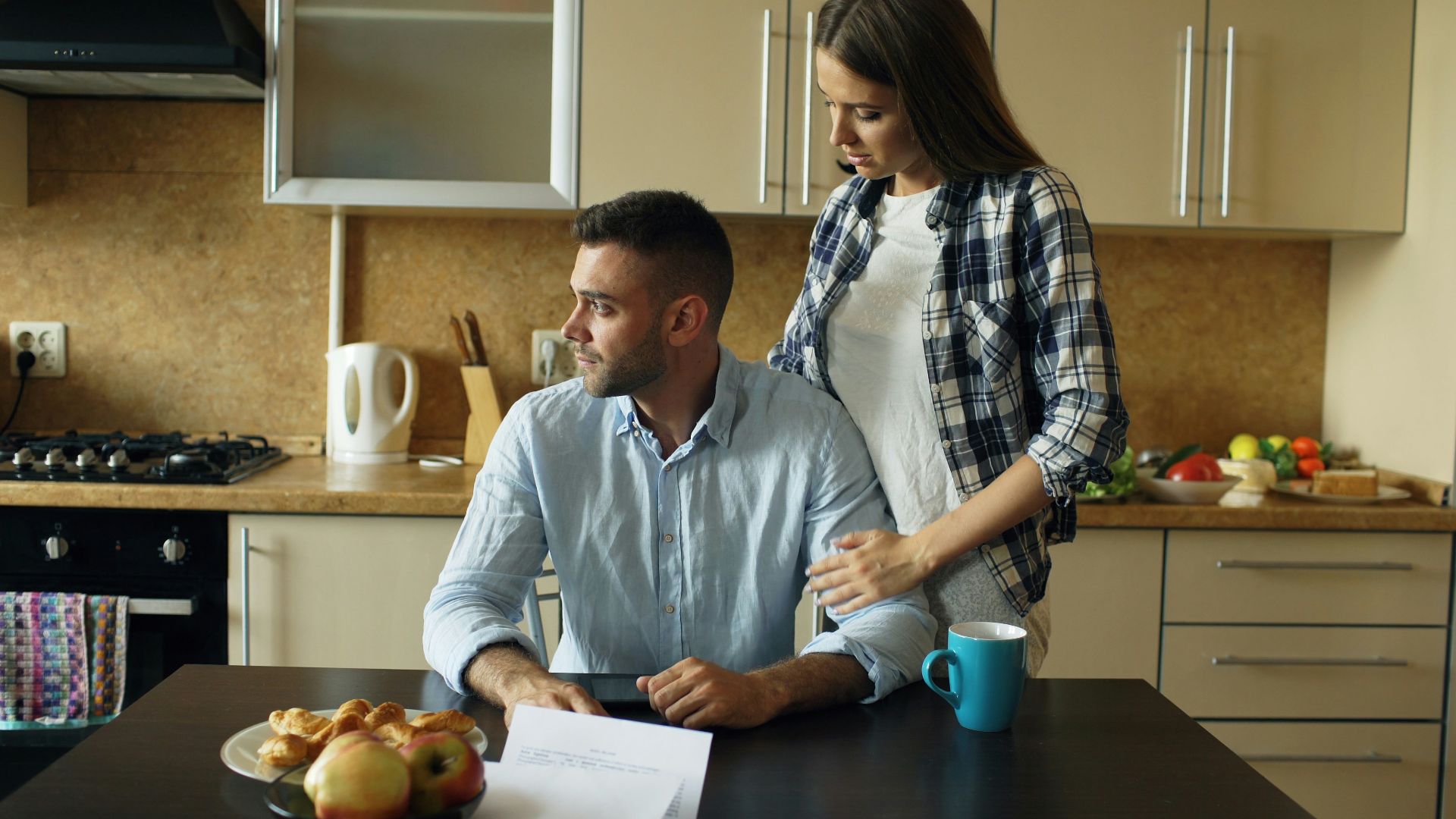 Couple sitting at kitchen table with pastries