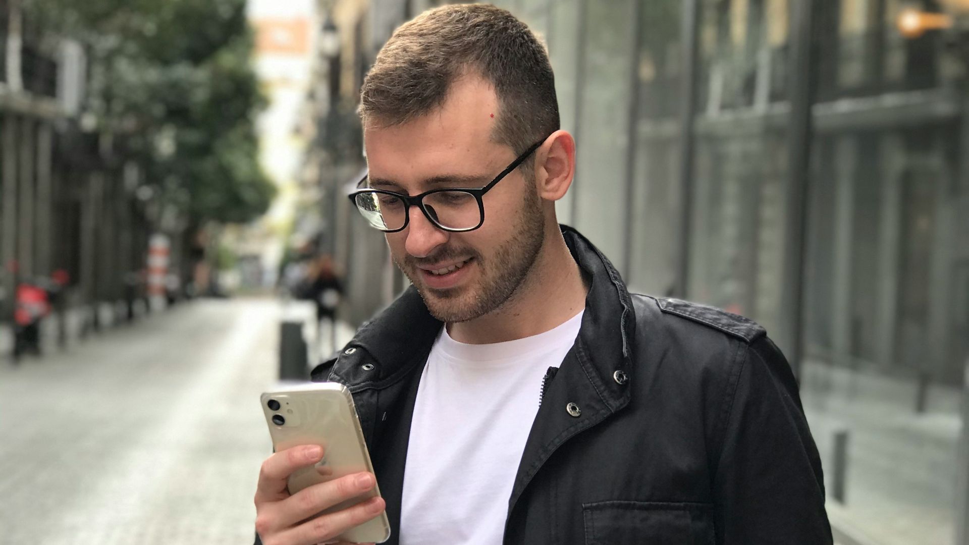 man in black full-zip jacket using smartphone