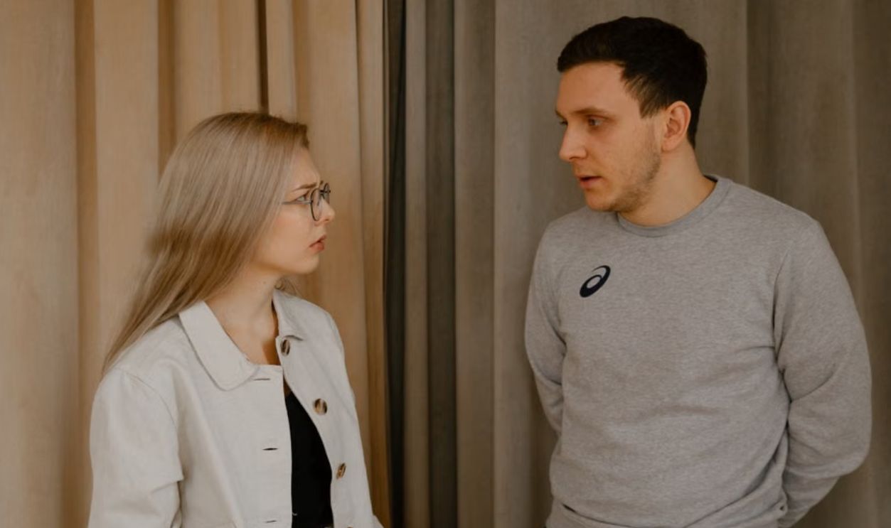 Man and woman having a serious conversation indoors, focused expressions
