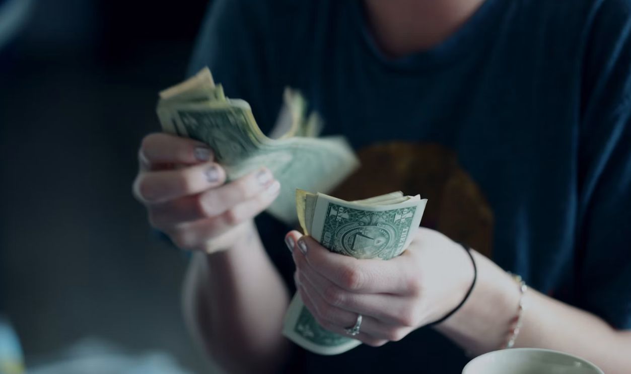 focus photography of person counting dollar banknotes