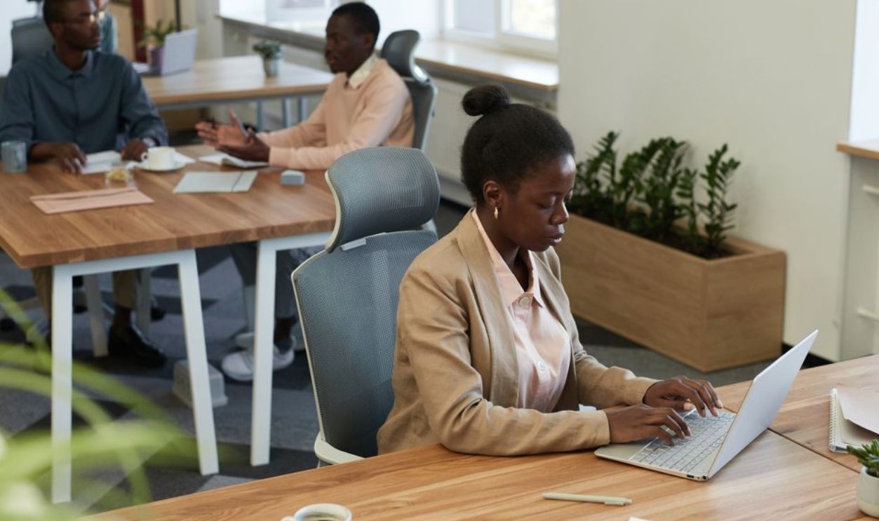 Diverse group of professionals collaborating in a modern office setting with laptops and discussions