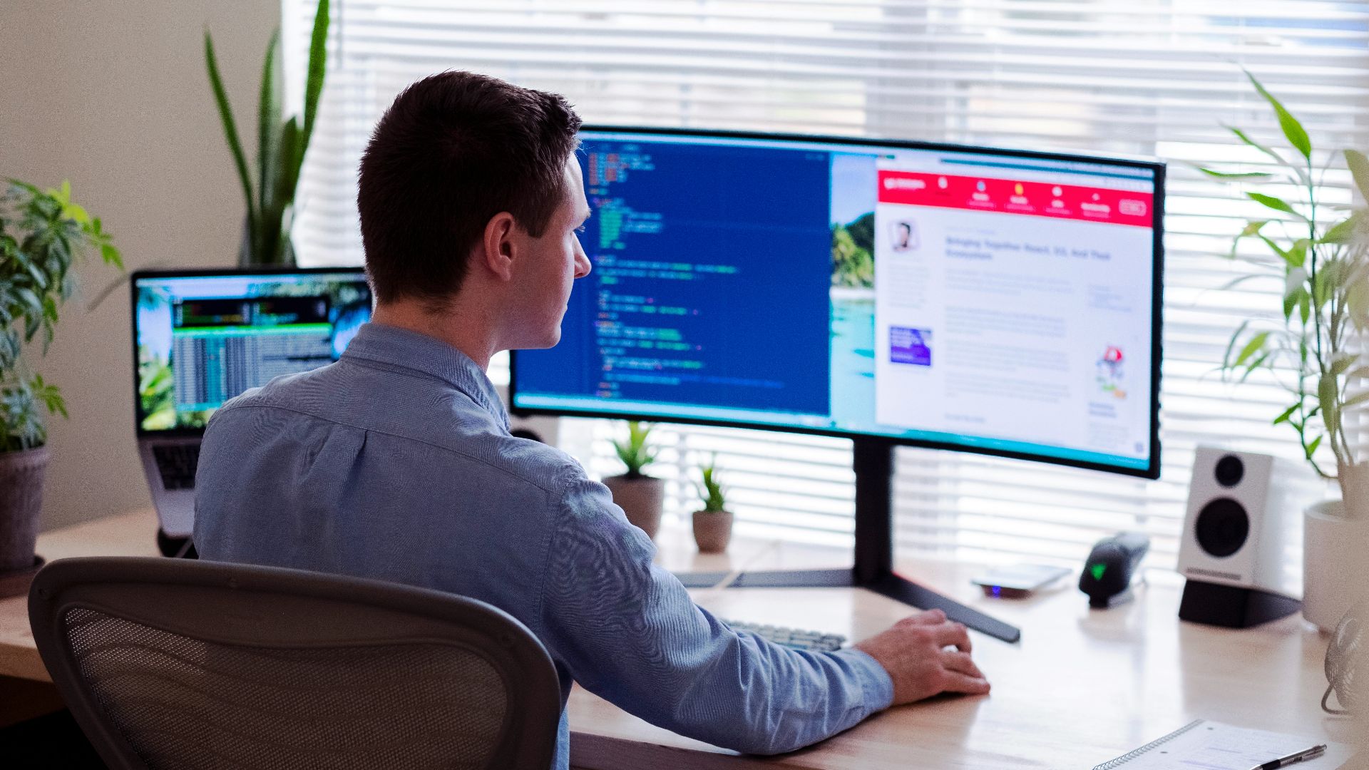 man in gray dress shirt sitting on chair in front of computer monitor