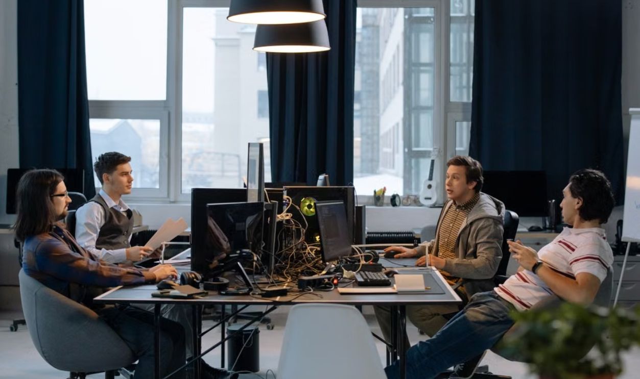Young professionals collaborating in a vibrant office setting with computers and documents