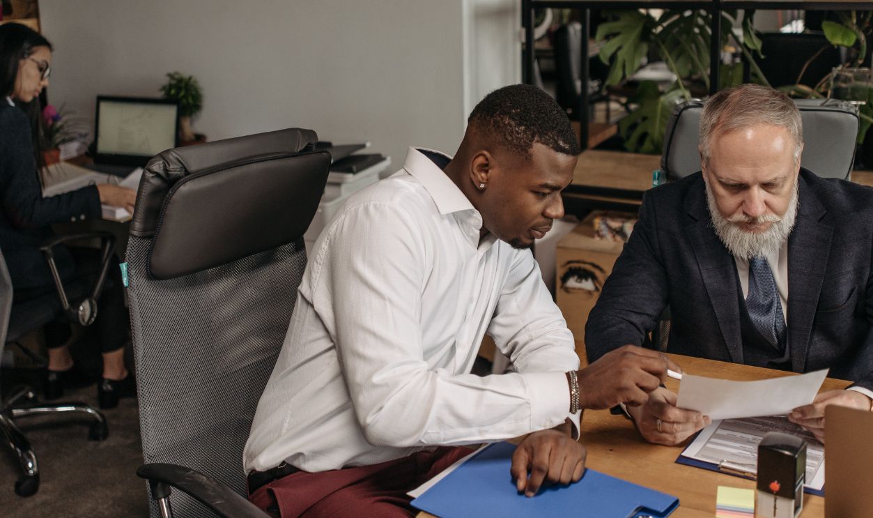 Professional team in office setting reviewing documents and working on business strategy