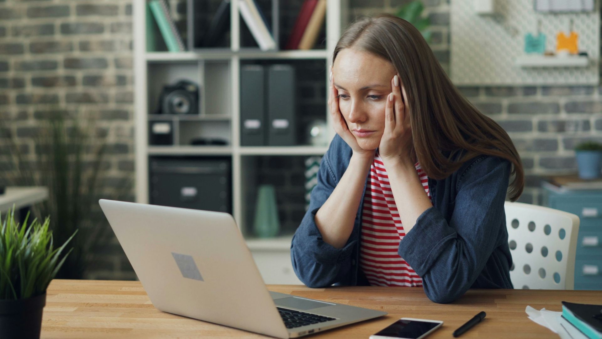 a woman sitting at a table with a laptop in front of her