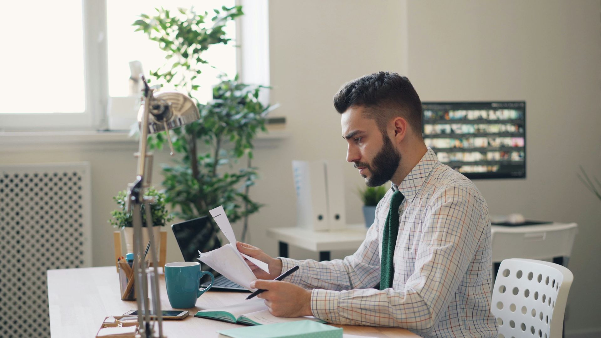 a man sitting at a desk with a laptop and papers