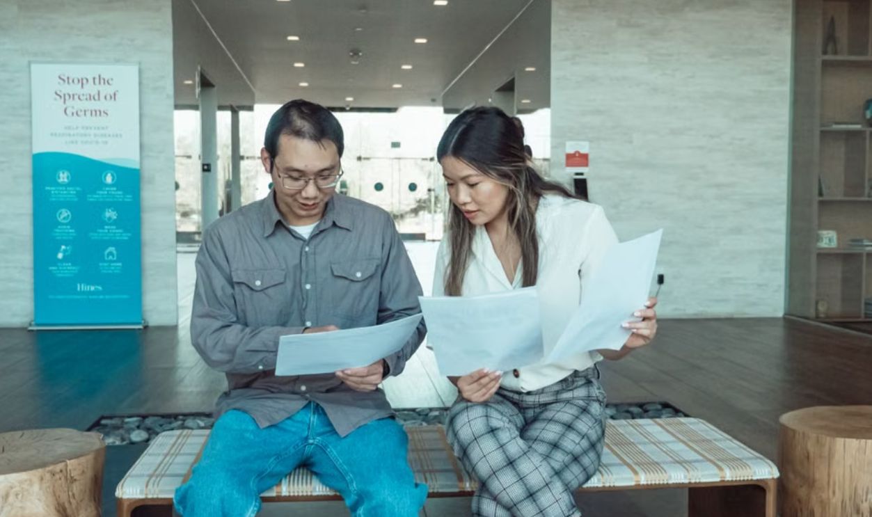 Two business colleagues discussing documents in a modern office setting.
