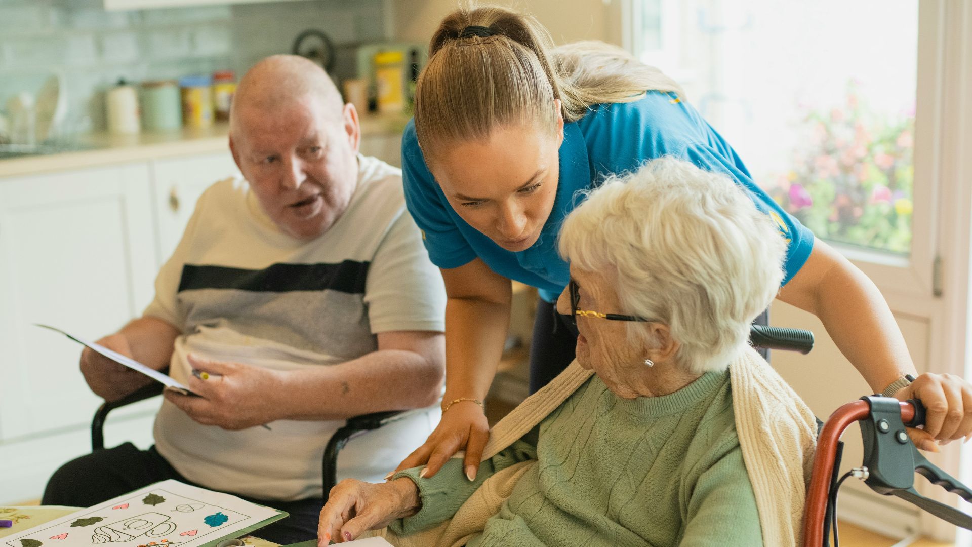 Caregiver assisting elderly couple with coloring
