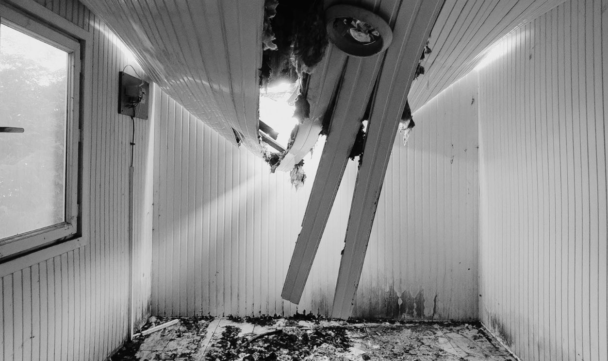 Interior of a room with a collapsed ceiling showing damage and debris